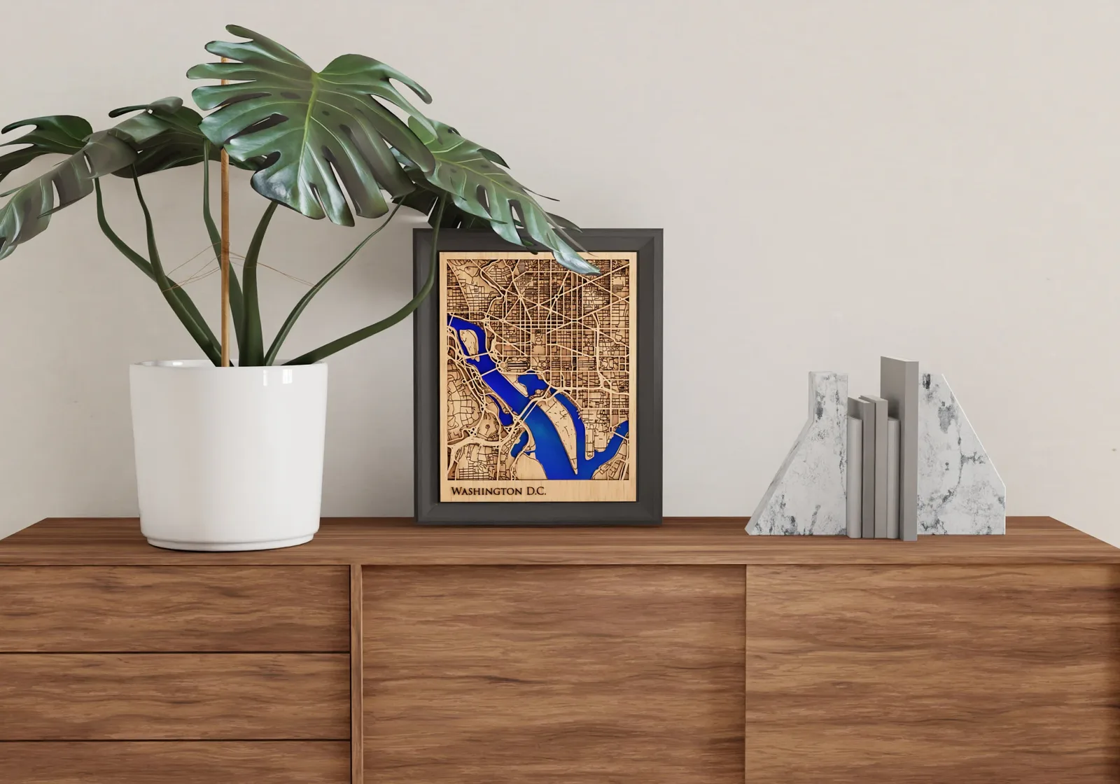 A framed Washington D.C. wood map styled on a walnut console
